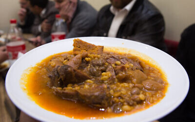 Illustrative. Ultra-Orthodox Jewish men eat cholent in Jerusalem, December 24, 2015 (Nati Shohat/Flash90)