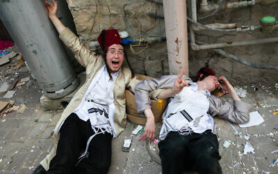 People celebrate the holiday of Purim in the ultra-orthodox Mea Shearim neighborhood in Jerusalem on March 11, 2020. (Olivier Fitoussi/Flash90)