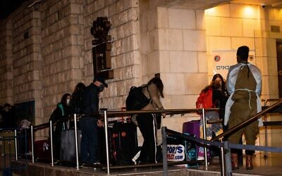 People who flew back to Israel seen arriving at the Dan Panorama Hotel used as a quarantine facility, on December 20, 2020. (Yonatan Sindel/Flash90)
