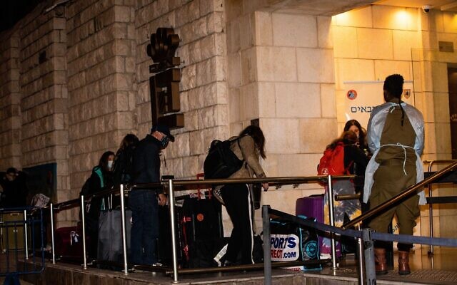 People who flew back to Israel seen arriving at the Dan Panorama Hotel used as a quarantine facility, on December 20, 2020. (Yonatan Sindel/Flash90) People who flew back to Israel seen arriving at the Dan Panorama Hotel used as a quarantine facility, on December 20, 2020. (Yonatan Sindel/Flash90)