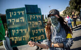 Sign reads 'The False Passport' as Israelis protest against the COVID-19 vaccine outside the Knesset in Jerusalem, January 4, 2021. (Yonatan Sindel/Flash90)