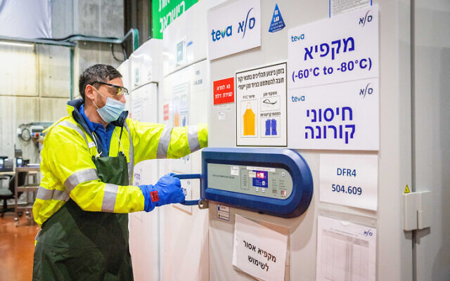 A worker at an israeli logistics center where coronavirus vaccines are stored and distributed, on January 7, 2021. (Yossi Aloni/Flash90) A worker at an israeli logistics center where coronavirus vaccines are stored and distributed, on January 7, 2021. (Yossi Aloni/Flash90)