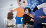 People receive a COVID-19 vaccine, at a sports hall turned into a vaccination center in Hod haSharon, February 2, 2021. (Miriam Alster/Flash90)