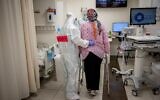 Shaare Zedek hospital team member wearing safety gear help a pregnant woman at the Coronavirus ward of Shaare Zedek hospital in Jerusalem on February 3, 2021 (Yonatan Sindel/Flash90)