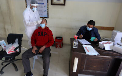 A Palestinian health worker takes samples for coronavirus at a health center in Rafah, in the southern Gaza Strip, on February 4, 2021. (Abed Rahim Khatib/Flash90)