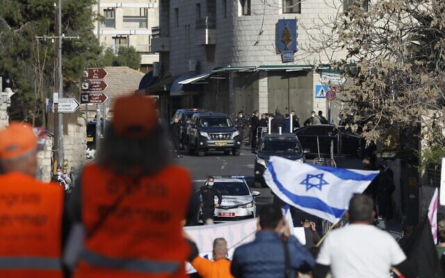 Protesters and security forces stand guard outside the Jerusalem District Court as Prime Minister Benjamin Netanyahu's convoy arrives for a hearing in his corruption trial, February 8, 2021. (Olivier Fitoussi/Flash90) Protesters and security forces stand guard outside the Jerusalem District Court as Prime Minister Benjamin Netanyahu's convoy arrives for a hearing in his corruption trial, February 8, 2021. (Olivier Fitoussi/Flash90)