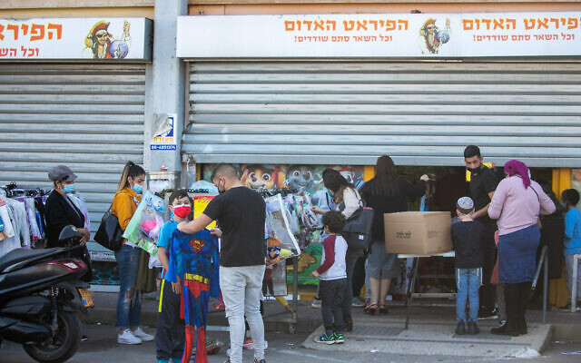 Israelis shop for Purim costumes at a Red Pirate toy store in Kiryat Ekron, ahead of the Jewish holiday of Purim, on February 14, 2021. (Yossi Aloni/FLASH90) Israelis shop for Purim costumes at a Red Pirate toy store in Kiryat Ekron, ahead of the Jewish holiday of Purim, on February 14, 2021. (Yossi Aloni/FLASH90)
