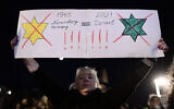 A protester apparently compares Israel's green vaccination certification to the Nazi laws forcing Jews to wear yellow stars in Tel Aviv, on February 15, 2021 (Tomer Neuberg/FLASH90)