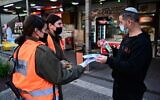 Soldiers from the Home Front command give out COVID-19 information in Katzrin, February 16, 2021 (Michael Giladi/Flash90)