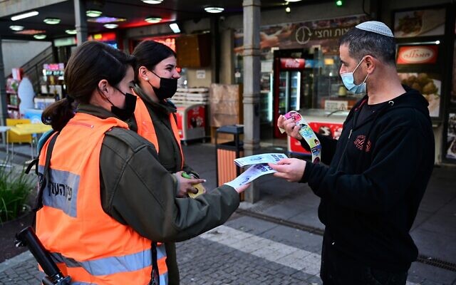 Soldiers from the Home Front command give out COVID-19 information in Katzrin, February 16, 2021 (Michael Giladi/Flash90) Soldiers from the Home Front command give out COVID-19 information in Katzrin, February 16, 2021 (Michael Giladi/Flash90)
