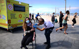 People receive a COVID-19 vaccine injection at a mobile vaccine station on the beach in Tel Aviv, February 20, 2021. (Tomer Neuberg/Flash90)