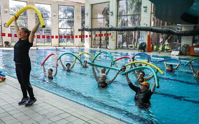People swim at the Holmes Place health club in Modiin on February 21, 2021, after it was opened for people who have been vaccinated or have recovered from COVID-19 (Yossi Aloni/Flash90)