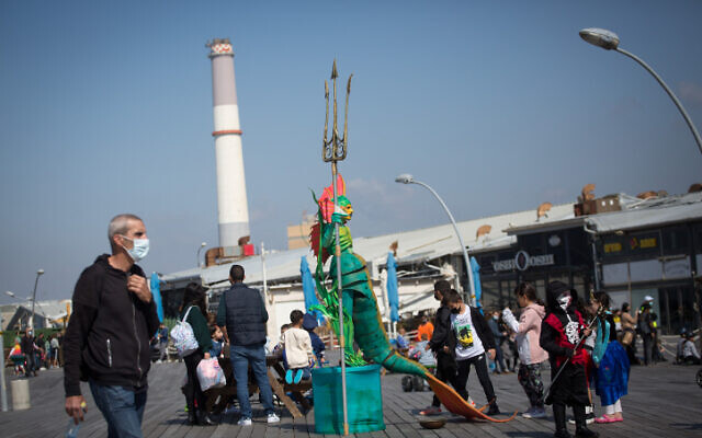 People dressed up in costumes attend a festival at the Tel Aviv Port to mark the Jewish holiday of Purim on February 25, 2021 (Miriam Alster/Flash90) People dressed up in costumes attend a festival at the Tel Aviv Port to mark the Jewish holiday of Purim on February 25, 2021 (Miriam Alster/Flash90)