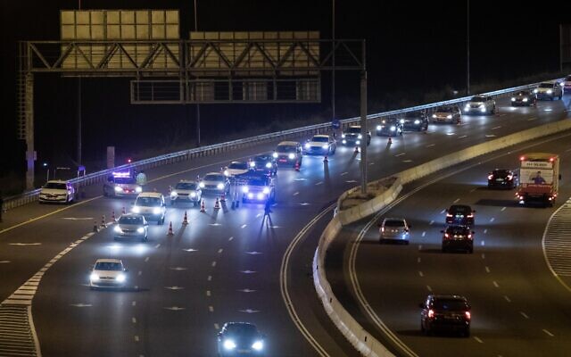 Police put up a temporary roadblock on Route 1 near Jerusalem during a nighttime curfew for the Jewish holiday of Purim, February 25, 2021 (Yonatan Sindel/Flash90) Police put up a temporary roadblock on Route 1 near Jerusalem during a nighttime curfew for the Jewish holiday of Purim, February 25, 2021 (Yonatan Sindel/Flash90)