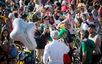 People wearing costumes celebrate the jewish holiday of Purim at Habima Square in Tel Aviv on February 26, 2021. (Miriam Alster/Flash90)