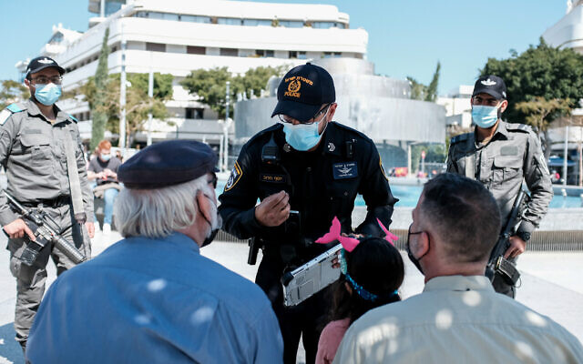 Israeli police officers enforce the COVID-19 regulations in Tel Aviv on February 27, 2021. (Tomer Neuberg/Flash90) Israeli police officers enforce the COVID-19 regulations in Tel Aviv on February 27, 2021. (Tomer Neuberg/Flash90)