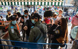 Police officers prevent revelers from entering Jerusalem's Mahane Yehuda market after they shut down a street party during the Jewish holiday of Purim, February 28, 2021. (Olivier Fitoussi/Flash90)