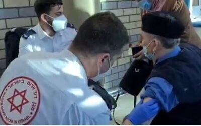 A MDA medic vaccinates a Palestinian worker in East Jerusalem on February 10, 2021 (Screencapture/Twitter)