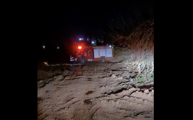 A firetruck is seen near the cemetery in Beit Yehoshua, where the body of a woman was found in the trunk of a burning car, February 16, 2021. (Screen capture: Channel 13 news) A firetruck is seen near the cemetery in Beit Yehoshua, where the body of a woman was found in the trunk of a burning car, February 16, 2021. (Screen capture: Channel 13 news)