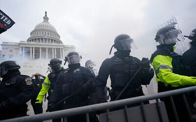 Police stand guard against Trump supporters at the US Capitol, Washington, January 6, 2021. (AP Photo/Julio Cortez, File)