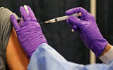 A man gets his COVID-19 vaccine at a mass vaccination site in Natick, Massachusetts, Feb. 24, 2021. (Matt Stone/The Boston Herald via AP, Pool)