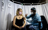 An Israeli receives a COVID-19 vaccine in Jerusalem, February 10, 2021. (Yonatan Sindel/Flash90)