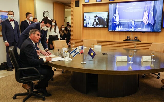 Foreign Minister Gabi Ashkenazi signs a joint declaration establishing ties with Kosovo during an official ceremony held over Zoom with his counterpart from Kosovo, Meliza Haradinaj Stublla, onscreen, at the Israeli Foreign Ministry headquarters in Jerusalem on February 1, 2021. (Menahem Kahana/AFP) Foreign Minister Gabi Ashkenazi signs a joint declaration establishing ties with Kosovo during an official ceremony held over Zoom with his counterpart from Kosovo, Meliza Haradinaj Stublla, onscreen, at the Israeli Foreign Ministry headquarters in Jerusalem on February 1, 2021. (Menahem Kahana/AFP)