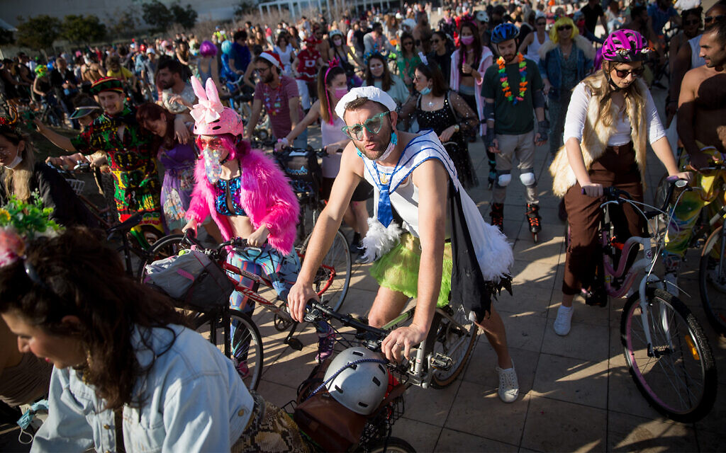 People wearing costumes celebrate  Purim at Habima Square in Tel Aviv, February 26, 2021. (Miriam Alster/Flash90)