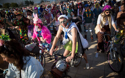 People wearing costumes celebrate  Purim at Habima Square in Tel Aviv, February 26, 2021. (Miriam Alster/Flash90)