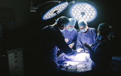 Illustrative image of a medical team performing surgery in an operating room. (jacoblund; iStock by Getty Images)