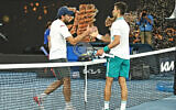 Aslan Karatsev (L) shakes hands with Novak Djokovic (R) at the Australian Open in Melbourne, Australia, Feb. 18, 2021 (Peter Haskin / Australian Jewish News)