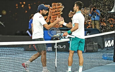 Aslan Karatsev (L) shakes hands with Novak Djokovic (R) at the Australian Open in Melbourne, Australia, Feb. 18, 2021 (Peter Haskin / Australian Jewish News)