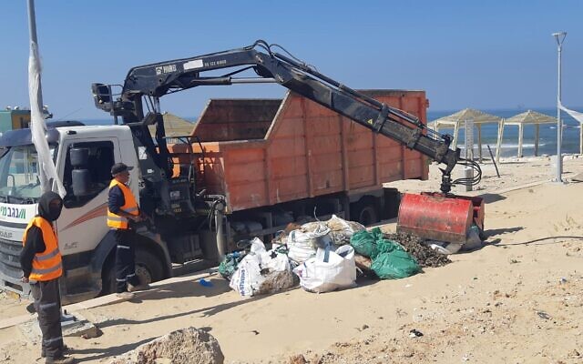 The Environmental Protection Ministry clearing tar from Israel's beaches following a major spill that contaminated the coastline, February 24, 2021. (Environmental Protection Ministry) The Environmental Protection Ministry clearing tar from Israel's beaches following a major spill that contaminated the coastline, February 24, 2021. (Environmental Protection Ministry)