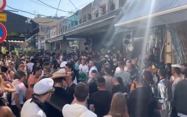 People celebrate the holiday of Purim in violation of coronavirus restrictions, at Jaffa's Flea Market in Tel Aviv-Jaffa, February 27, 2021 (video screenshot) People celebrate the holiday of Purim in violation of coronavirus restrictions, at Jaffa's Flea Market in Tel Aviv-Jaffa, February 27, 2021 (video screenshot)