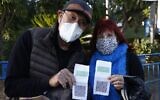 Israelis shows their "green pass" (proof of being fully vaccinated against the coronavirus) before entering the Green Pass concert for vaccinated seniors, organized by the municipality of Tel Aviv, on February 24, 2021. (JACK GUEZ / AFP)