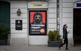 A woman wearing a protective facemask, as a preventive measure against the Covid-19 (the novel coronavirus), walks past a campaign poster, in favour of the 'burqa ban' initiative reading in German: 'Stop extremism!' on March 3, 2021 in the streets of Zurich, ahead of a nationwide vote on March 7, 2021 by Swiss citizen on whether to ban full facial coverings in public places. (Fabrice COFFRINI / AFP)