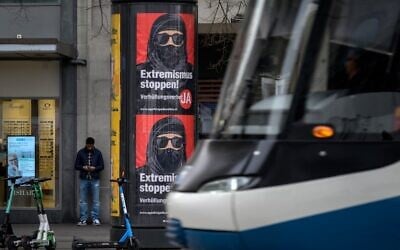 A tram passes by campaign posters in favor of the 'burqa ban' initiative reading in German: 'Stop extremism!' on March 3, 2021 in the streets of Zurich, ahead of a nationwide vote on March 7, 2021, by Swiss citizen on whether to ban full facial coverings in public places. (Fabrice COFFRINI / AFP)