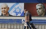 People walk past an electoral billboard for the Likud party bearing a portrait of its leader Prime Minister Benjamin Netanyahu (L), and opposition Yesh Atid party leader Yair Lapid, in Tel Aviv, on March 12, 2021, ahead of the March 23 general election. (JACK GUEZ / AFP)