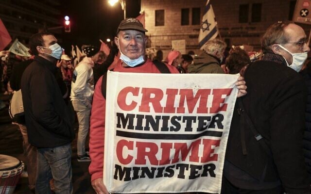 Erez Yalon, a disabled Israeli who for nearly a year has dedicated his life to protesting outside Prime Minister Benjamin Netanyahu's residence in Jerusalem, holds a banner as he is joined by other protesters, on March 13, 2021. - (MENAHEM KAHANA / AFP) Erez Yalon, a disabled Israeli who for nearly a year has dedicated his life to protesting outside Prime Minister Benjamin Netanyahu's residence in Jerusalem, holds a banner as he is joined by other protesters, on March 13, 2021. - (MENAHEM KAHANA / AFP)