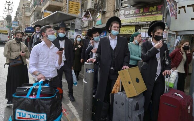 People wait at a bus stop in an ultra-Orthodox Jewish neighborhood in Jerusalem, on March 11, 2021 (MENAHEM KAHANA / AFP) People wait at a bus stop in an ultra-Orthodox Jewish neighborhood in Jerusalem, on March 11, 2021 (MENAHEM KAHANA / AFP)