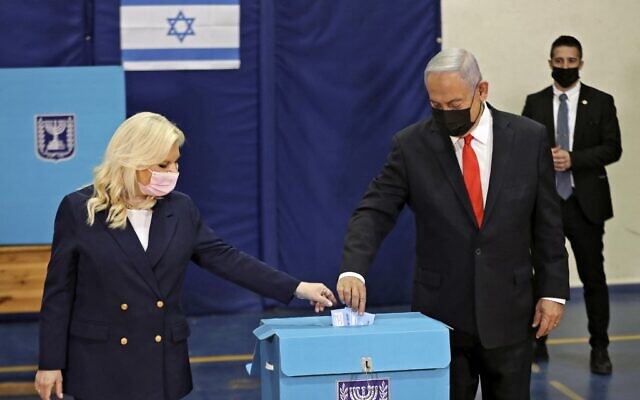 Prime Minister Benjamin Netanyahu and his wife Sara cast their ballots at a polling station in Jerusalem on March 23, 2021 in the fourth national election in two years. (RONEN ZVULUN / POOL / AFP)