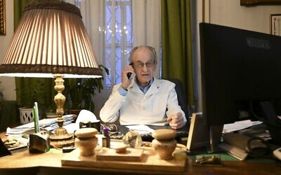 97-year-old Hungarian doctor Istvan Kormendi speaks on phone in his doctor's office at his home in Budapest on March 22, 2021. (ATTILA KISBENEDEK / AFP)