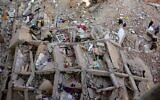 People and rescuers gather around the rubble of a building that collapsed in the popular area of Gesr Giza, east of the Egyptian capital Cairo, on March 27, 2021 (AFP)