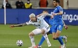 Scotland's forward Lyndon Dykes (L) is challenged by Israel's defender Eitan Tibi (C, back) during the 2022 FIFA World Cup qualifier group F football match between Israel and Scotland at Bloomfield stadium in Tel Aviv on March 28, 2021. (JACK GUEZ / AFP)