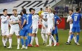 Players greet each other at the end of the 2022 FIFA World Cup qualifier group F football match between Israel and Scotland at Bloomfield stadium in the Israeli Mediterranean coastal city of Tel Aviv on March 28, 2021. (JACK GUEZ / AFP)
