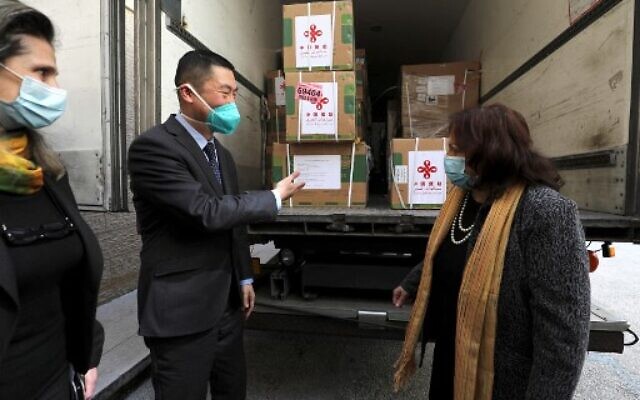 Chinese Ambassador Guo Wei (L) speaks with Palestinian Health Minister Mai al-Kaila during the unloading of a shipment of the Sinopharm COVID-19 vaccines donated by the Chinese government in the city of Ramallah in the West Bank, on March 29, 2021. (ABBAS MOMANI/AFP) Chinese Ambassador Guo Wei (L) speaks with Palestinian Health Minister Mai al-Kaila during the unloading of a shipment of the Sinopharm COVID-19 vaccines donated by the Chinese government in the city of Ramallah in the West Bank, on March 29, 2021. (ABBAS MOMANI/AFP)