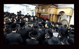 Hundreds of men crowded into a study hall for the funeral of Rabbi Yechezkel Roth on March 7, 2021. (Screenshot from BoroPark24 via JTA)