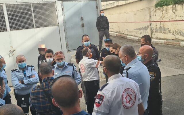 Police and paramedics at the scene where a man died of stab wounds on Hahagana Road in Tel Aviv, March 9, 2021. (Israel Police) Police and paramedics at the scene where a man died of stab wounds on Hahagana Road in Tel Aviv, March 9, 2021. (Israel Police)