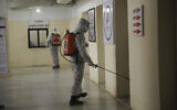 Illustrative: Members of a humanitarian aid agency disinfect Ibn Sina hospital as prevention against coronavirus in the city of Idlib, Syria, March 19, 2020. (AP Photo/Ghaith Alsayed)