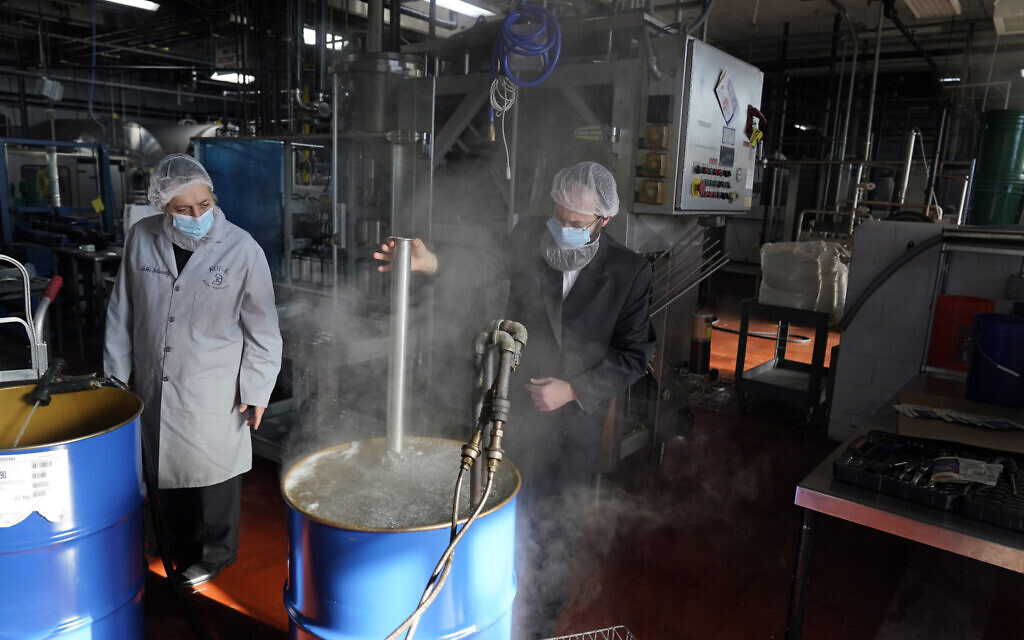 Rabbis Joseph Schwartz, left, and Mendel Einhorn kosherize equipment in boiling water as they help Hanan Products prepare for their kosher-for-Passover production run on Jan. 7, 2021, in Hicksville, N.Y. (AP Photo/Seth Wenig)
